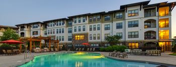 Pool deck with tables chairs umbrellas at mirabelle apartments in mobile, al